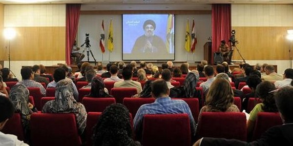 Hassan Nasrallah, líder de Hizbulá. Varias personas siguen desde Beirut el discurso de Hassan Nasrallah, líder de Hizbulá.