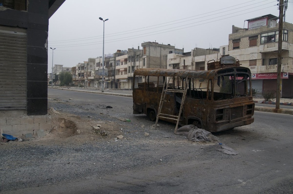 autobús calcinado en Homs (Siria)