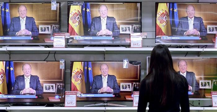 Una mujer observa las televisiones en un centro comercial de Valladolid, ayer, durante la retransmisión del mensaje del rey Juan Carlos. / Nacho Gallego (Efe)