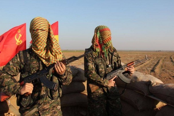 Los dos voluntarios españoles en el Kurdistán sirio. Detrás se ven las banderas del MLKP y de la II República Española. / Comité de Solidaridad con el Pueblo Kurdo y Rojava