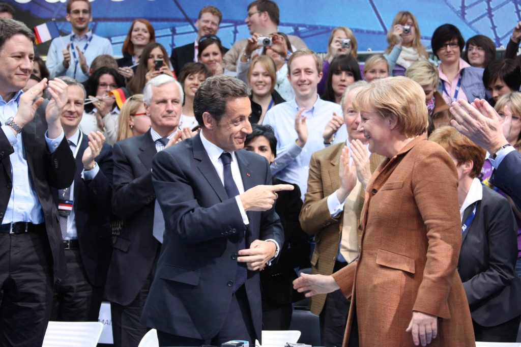 Crisis bancaria El entonces presidente francés Nicolas Sarkozy y la canciller alemana Angela Merkel bromean durante un acto de la Unión de Juventudes Alemanas