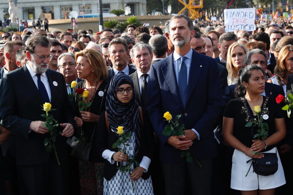 Mientras todos permanecen en silencio, una vez llegada la manifestación antiterrorista a la Plaza de Catalunya, Mariano Rajoy conversa con María Dolores de Cospedal