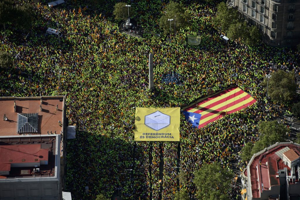 Una estelada sale de una pancarta en la que figuran una urna y la leyenda "referèndum és democrácia"