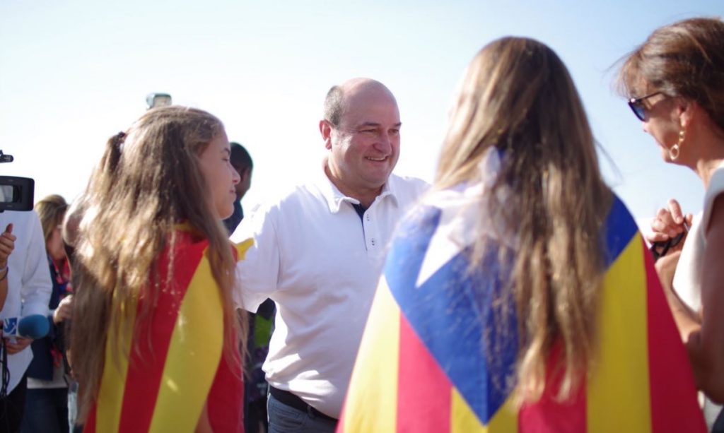 Andoni Ortuzar, presidente del PNV, conversa con una mujer, a la que acompañan dos niñas ataviadas con senyeras esteladas