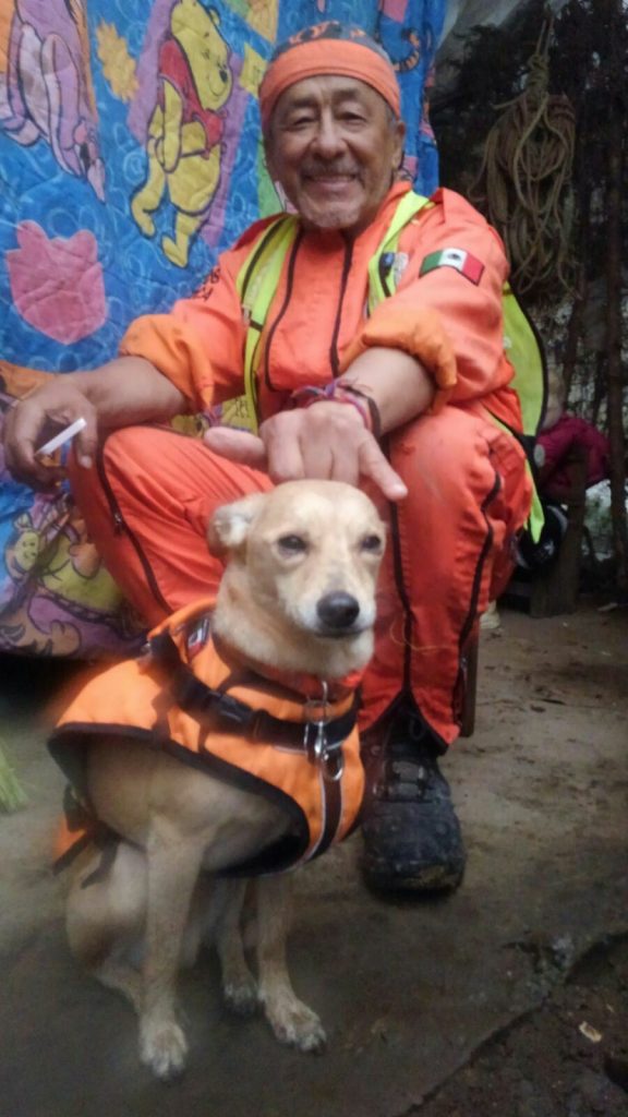 Héctor 'El Chino' Méndez, fundador de los Topos Aztecas, posa con Campeón, uno de los perros rastreadores de la brigada