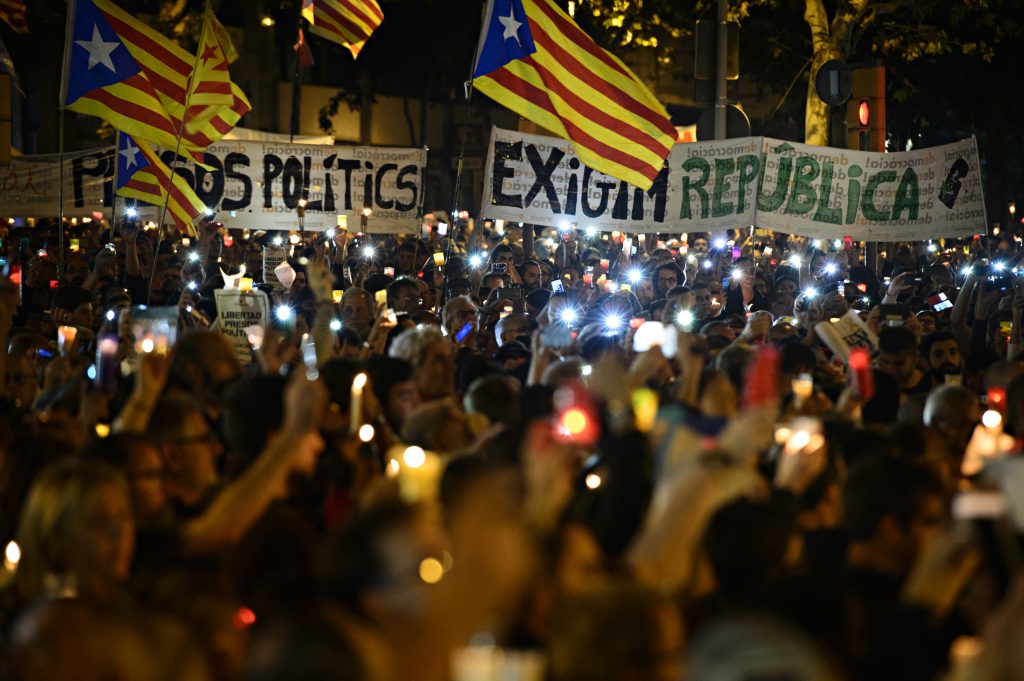 Los manifestantes enarbolan dos pancartas, una denunciando la existencia de presos políticos y otra exigiendo la república