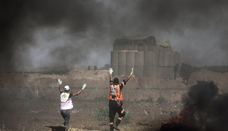 Personal médico palestino pide a los soldados israelíes que dejen de disparar mientras atienden a los manifestantes heridos durante los enfrentamientos en la Franja de Gaza.