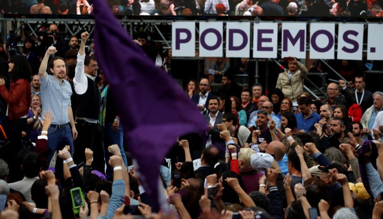 El secretario general de Podemos, Pablo Iglesias (i), junto al cofundador del partido, Juan Carlos Monedero (2i), durante el acto con el que Podemos inicia su campaña electoral, esta tarde en la plaza del museo del Reina Sofía, en Madrid.